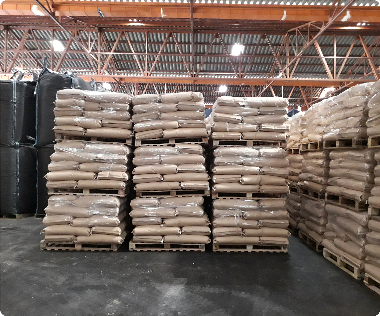 Warehouse with stacked pallets of bags.