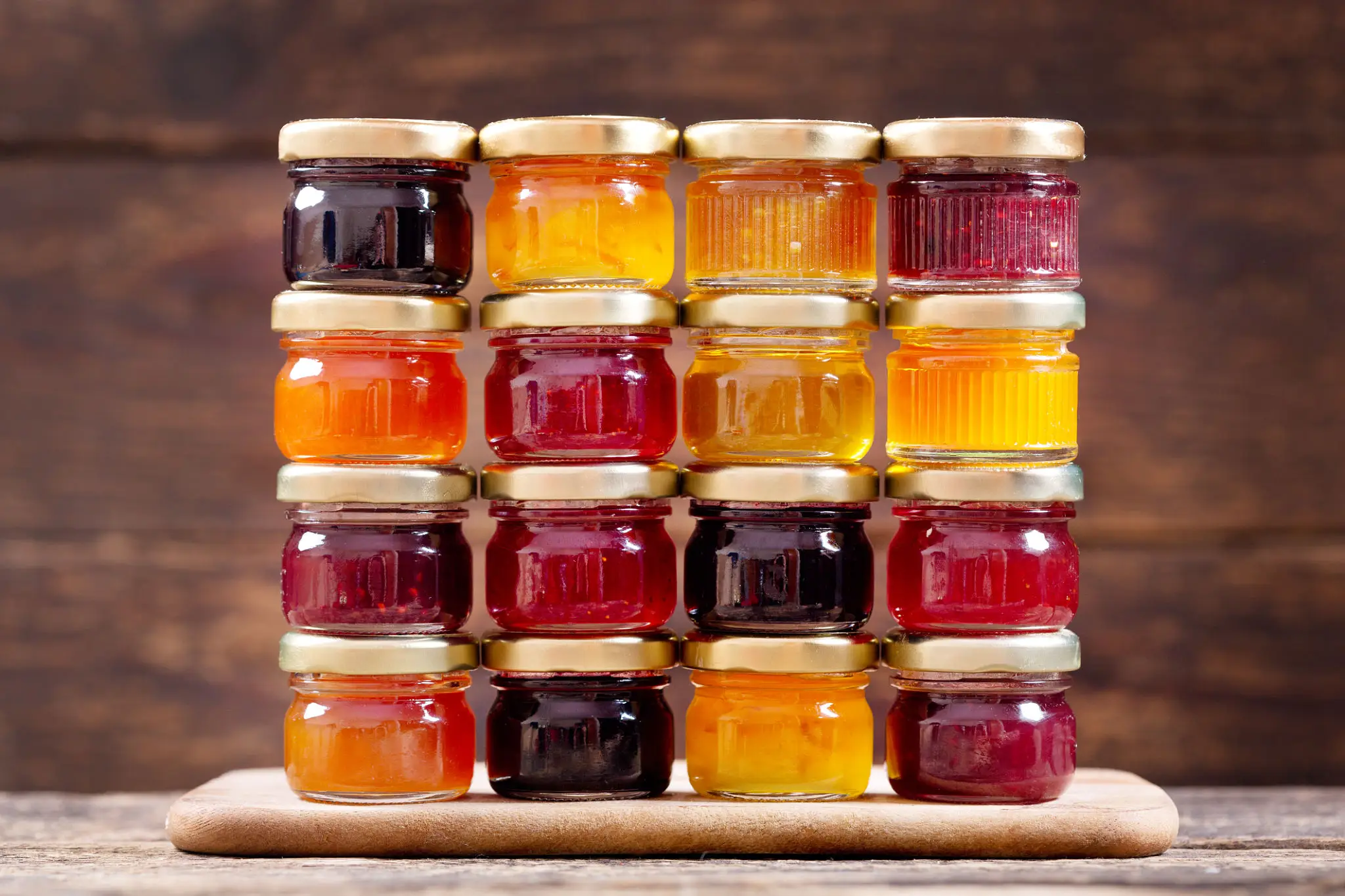 Stacked jars of colorful fruit preserves and jams.